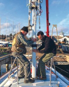 riggers Brion Toss (left) and IanWeedman help guide the mast out of the
boat on a clear November afternoon.