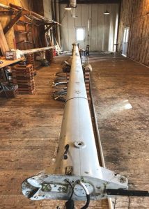 Marty's mast in the cavernous mastroom at Brion Toss Yacht Riggers. The
shrouds and stays are coiled below it.