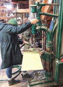 Making backing plates from a sheet ofG10 using a turn-of-the-century drill
press at Spaulding Marine Center.