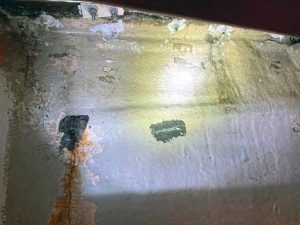 a view inside the port bulkhead before the workstarted shows a rusty drip at the corner of the embedded chainplate assembly.