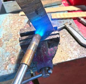 the author heats the backstay chainplatesbefore heat-bending. The orientation of the future bend can be seen as a chalk line under the flame.