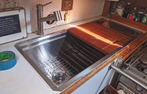 The new sink, drying rack, and cutting board shine.