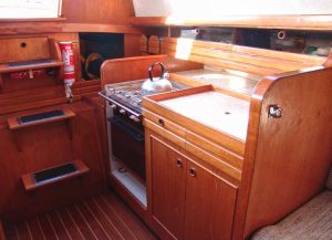 the compact galley features atwo-burner stove and oven, a small sink,
and limited stowage.
